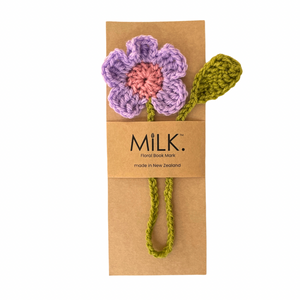A handmade crochet flower book mark by Milk, featuring a lavender and pink flower with an olive green stem and leaf, attached to a brown kraft paper card.
