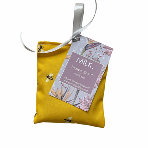 Yellow drawer scent bag with a tag labeled 'MILK.' on a white background