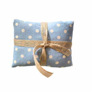 Blue polka dot fabric package with a brown ribbon on a white background