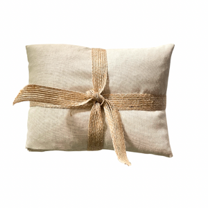 Beige pillow with a burlap ribbon on a white background