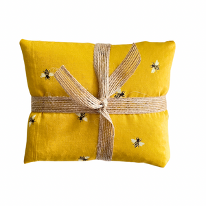 Yellow fabric wheat bag with a bee pattern 